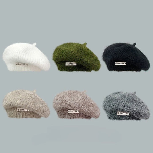 Six fuzzy knit berets in different colors are arranged in a 2x3 grid on a plain light gray background. The berets are white, olive green, black, light beige, taupe, and heather gray.