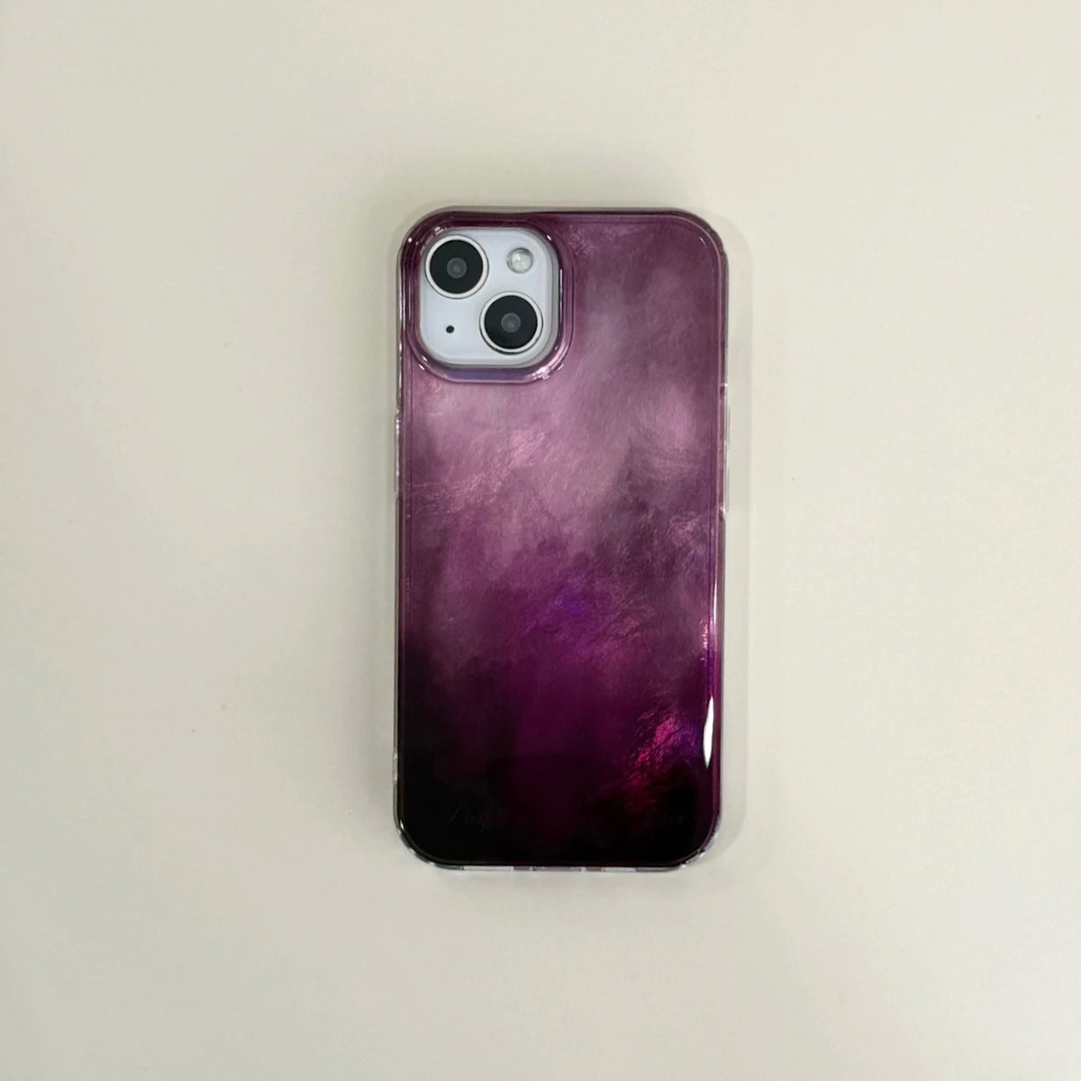 A phone case with a glossy purple and black gradient design, shown on a light beige background.