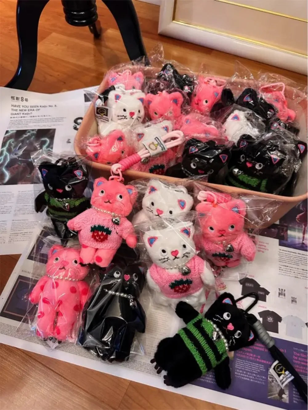 Plush keychains in various colors and designs on a newspaper surface.