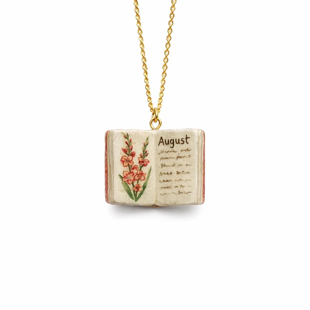 Necklace with an open book charm featuring floral illustrations and the word 'August'.