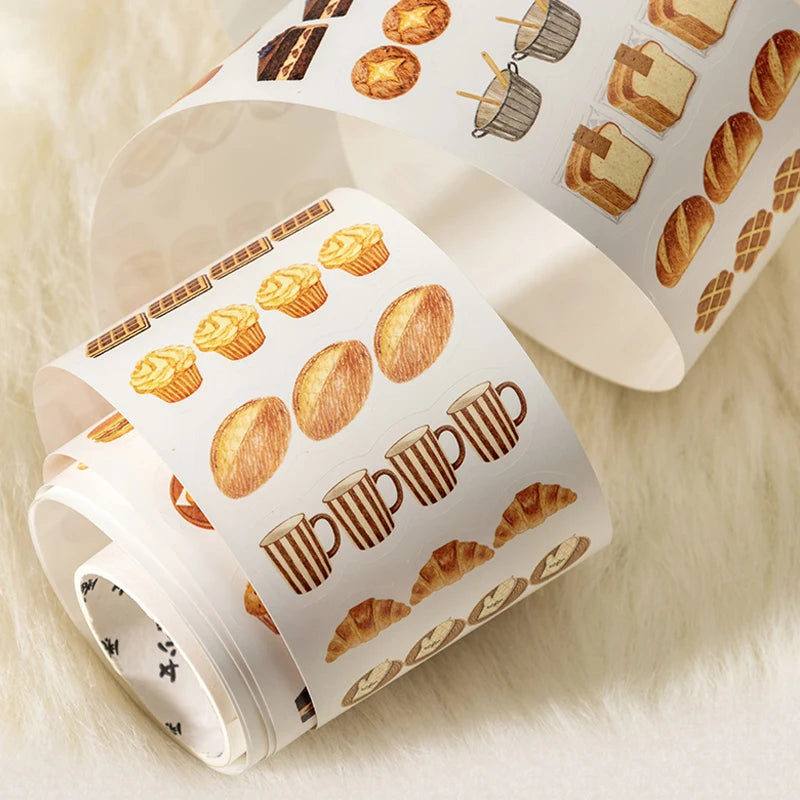 Roll of decorative paper with food-themed pattern on a soft surface