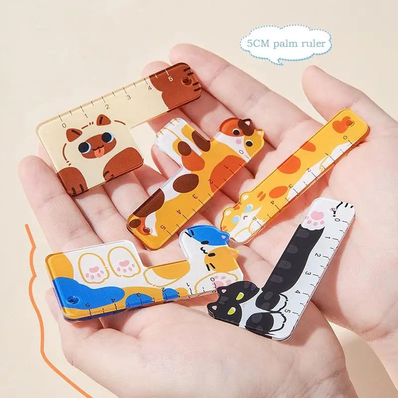 Set of cartoon animal-themed rulers held in a hand on a beige background