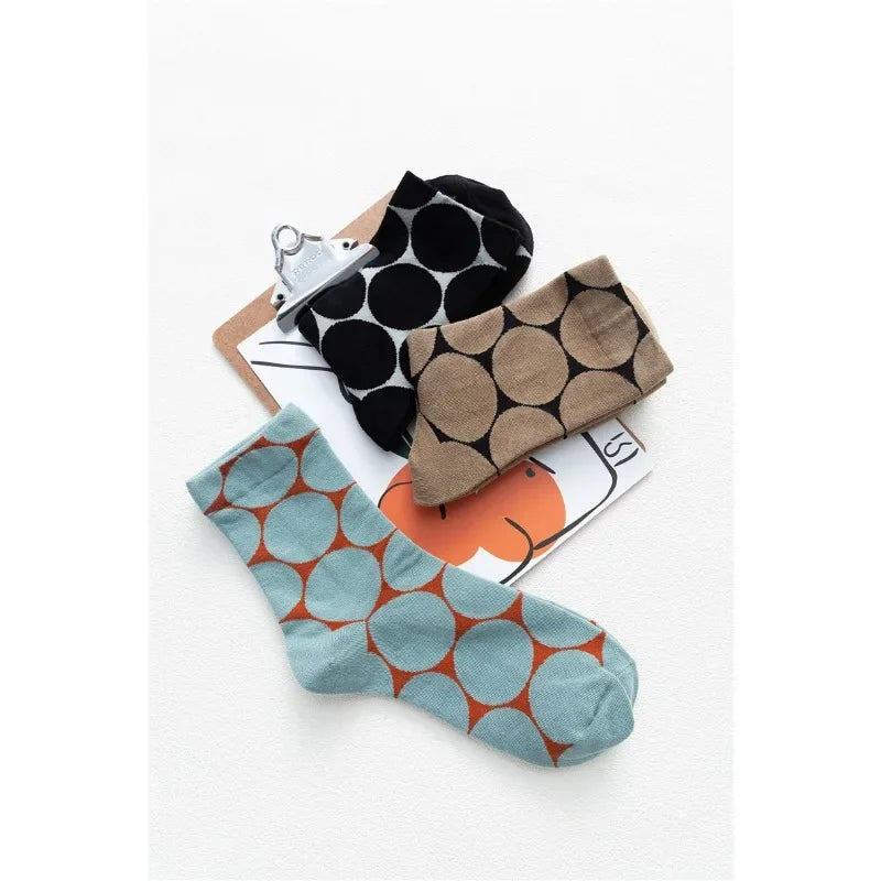 Three pairs of patterned socks on a white background