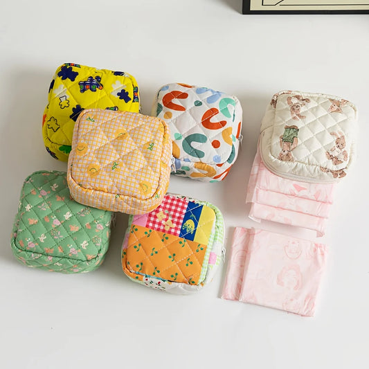 Set of colorful quilted pouches and cloths on a light background