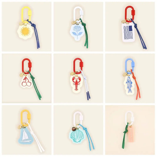 Collection of colorful keychains with various designs on a beige background