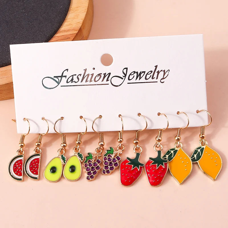 Fruit-shaped earrings on a 'Fashion Jewelry' card against a beige background