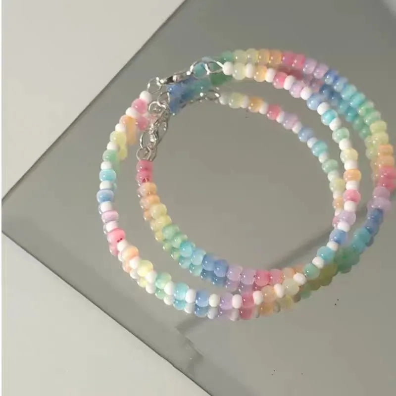 Pastel beaded necklace on a reflective surface