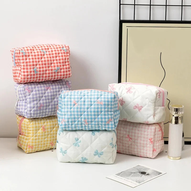 Stack of colorful quilted products with butterfly patterns on a white surface.