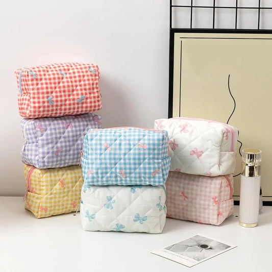 Stack of colorful quilted products with butterfly patterns on a white surface.