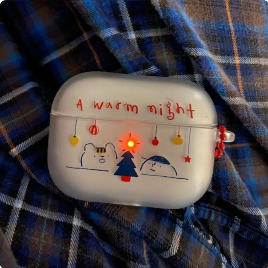 White airpod case with Christmas-themed design and text on a plaid fabric background