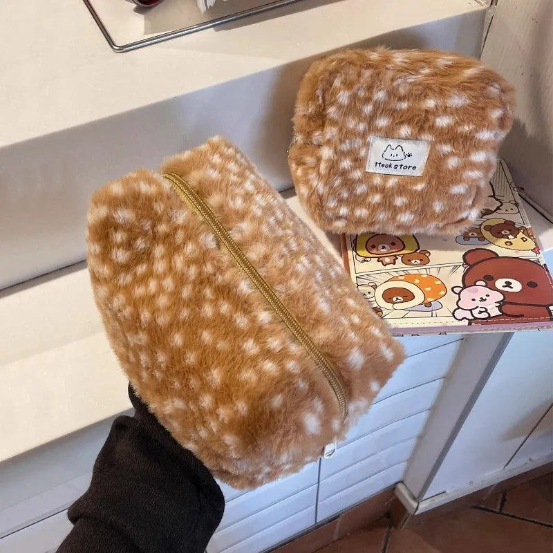 Two brown plush pouches with a gold zipper on a kitchen counter.