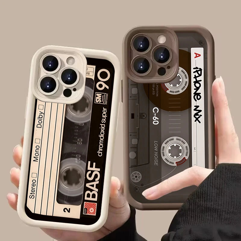 Two phone cases with cassette tape design held by a hand against a beige background