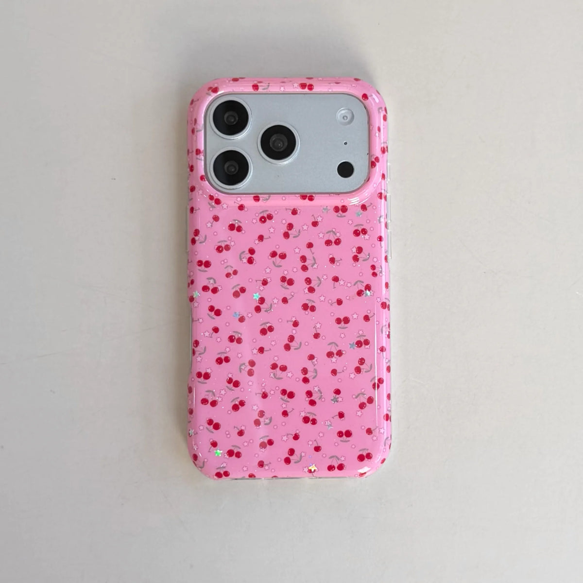 Pink phone case with red dot pattern on a light gray background