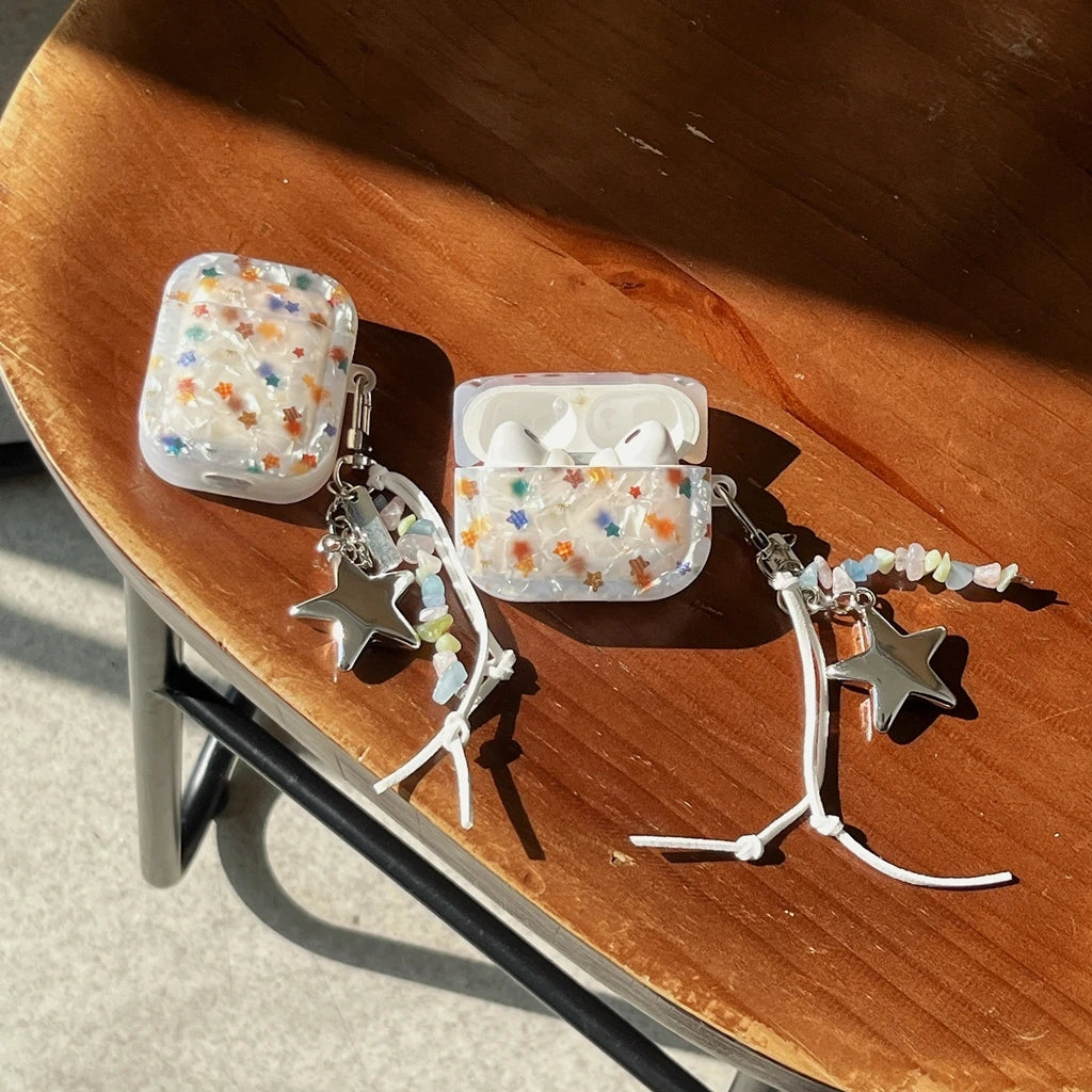 Two clear cases with colorful star and star-shaped charms on a wooden surface.