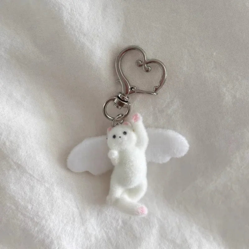 White angel keychain with a heart-shaped clip on a white background