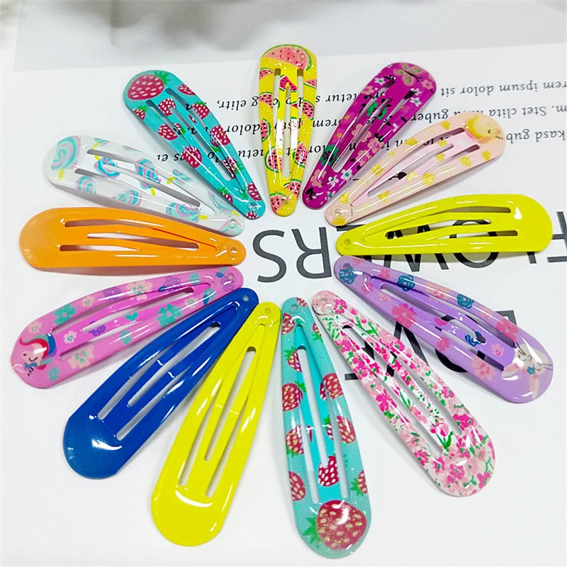 A set of 12 colorful hair claw clips arranged in a circular pattern on a white background with printed text. The clips feature various designs including solid colors, floral prints, strawberry patterns, and cartoon motifs in pink, blue, yellow, purple, orange, and green.