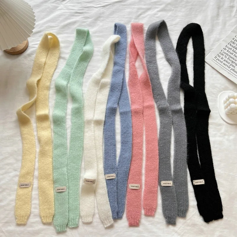 Set of colorful knitted skinny scarves on a white surface