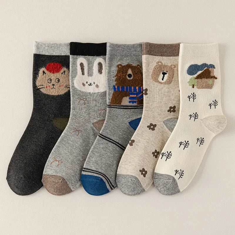 Set of five pairs of socks with animal and nature designs on a light background