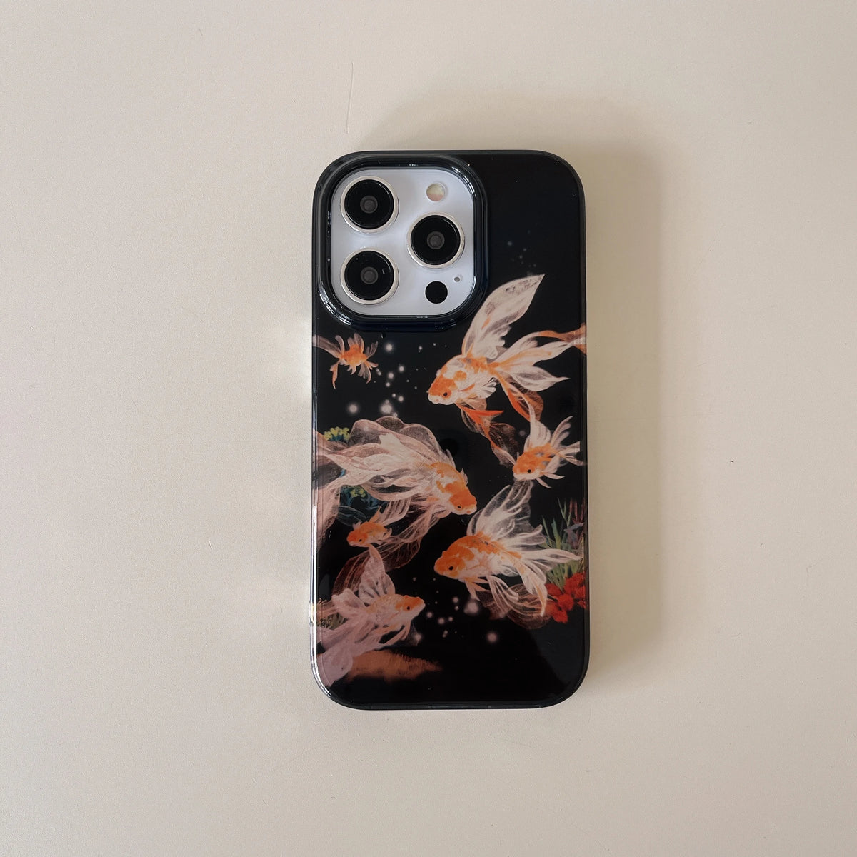 Phone case with goldfish design on a beige background