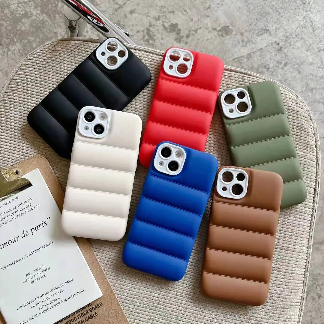 Set of six colorful phone cases on a textured surface with a magazine underneath.