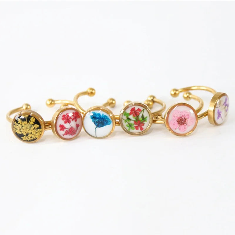 Set of floral-themed gold bracelets on a white background