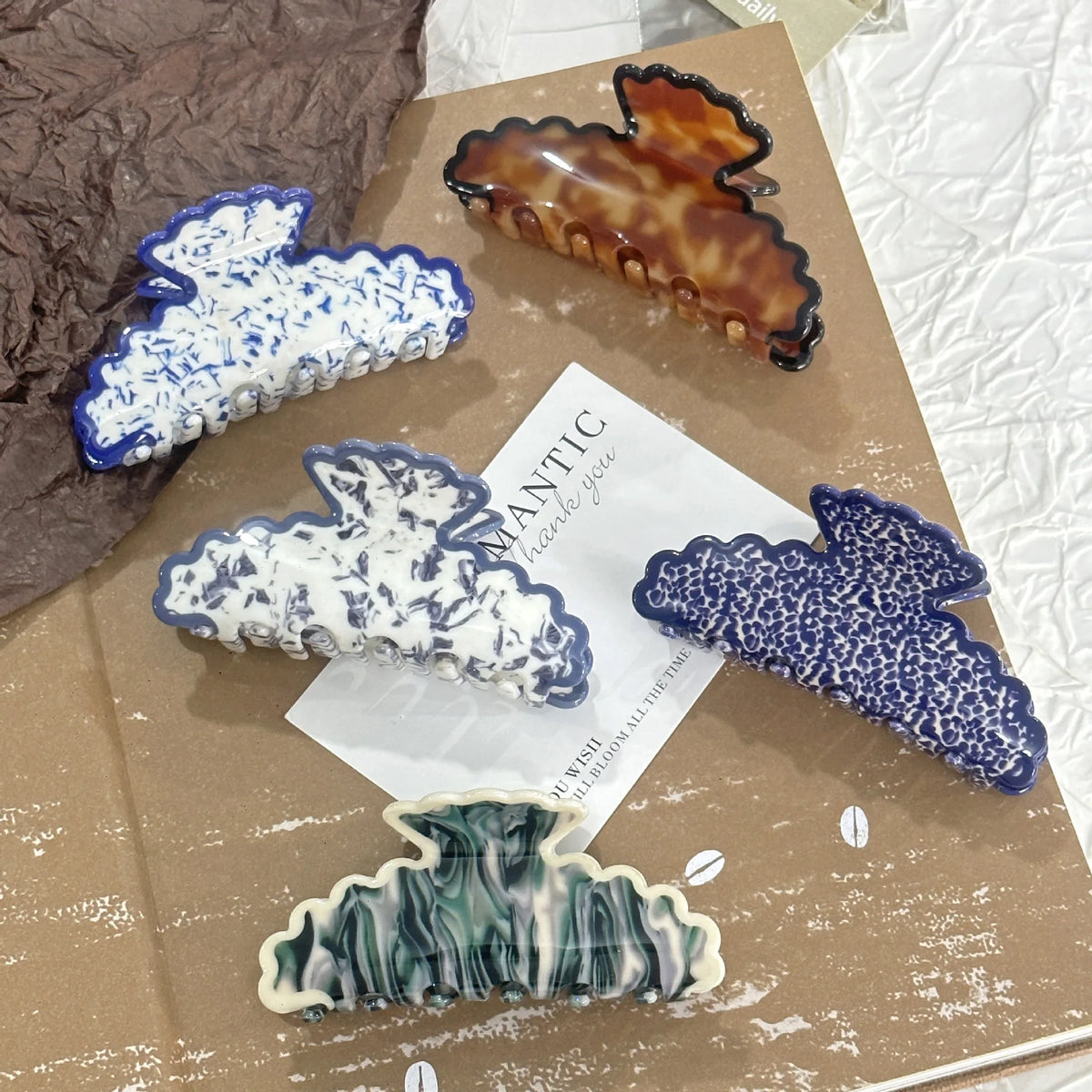 Set of decorative hair clips on a textured surface with a card in the center.