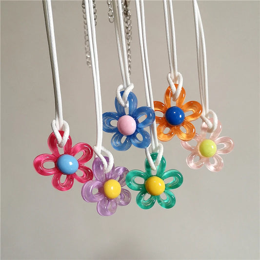 Colorful flower-shaped necklaces with bead centers on a neutral background