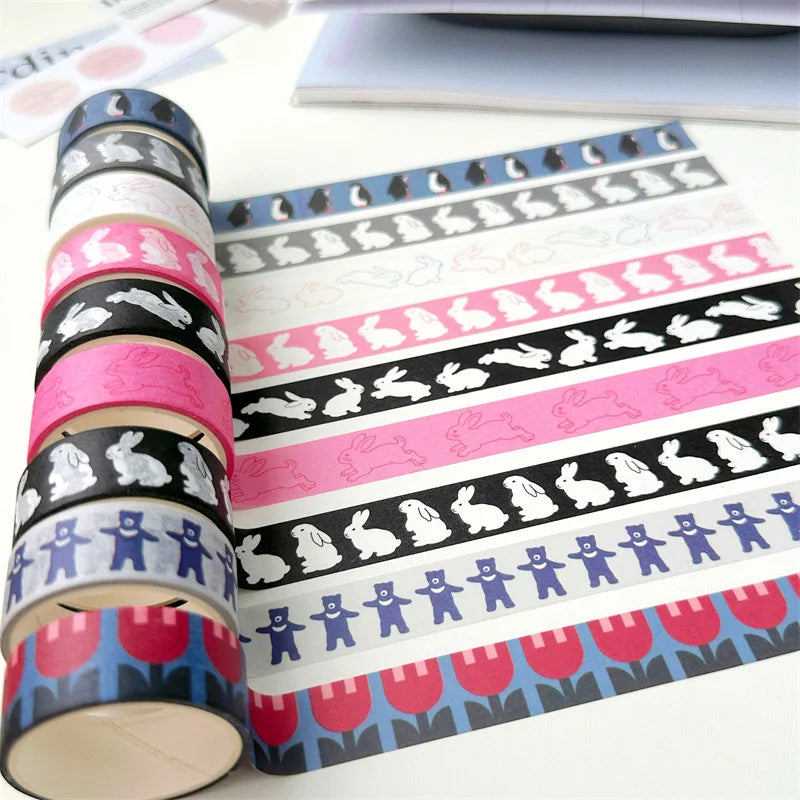 A set of decorative washi tapes with Easter-themed patterns, including bunnies, tulips, and teddy bears, shown in rolls and laid out on a white surface.
