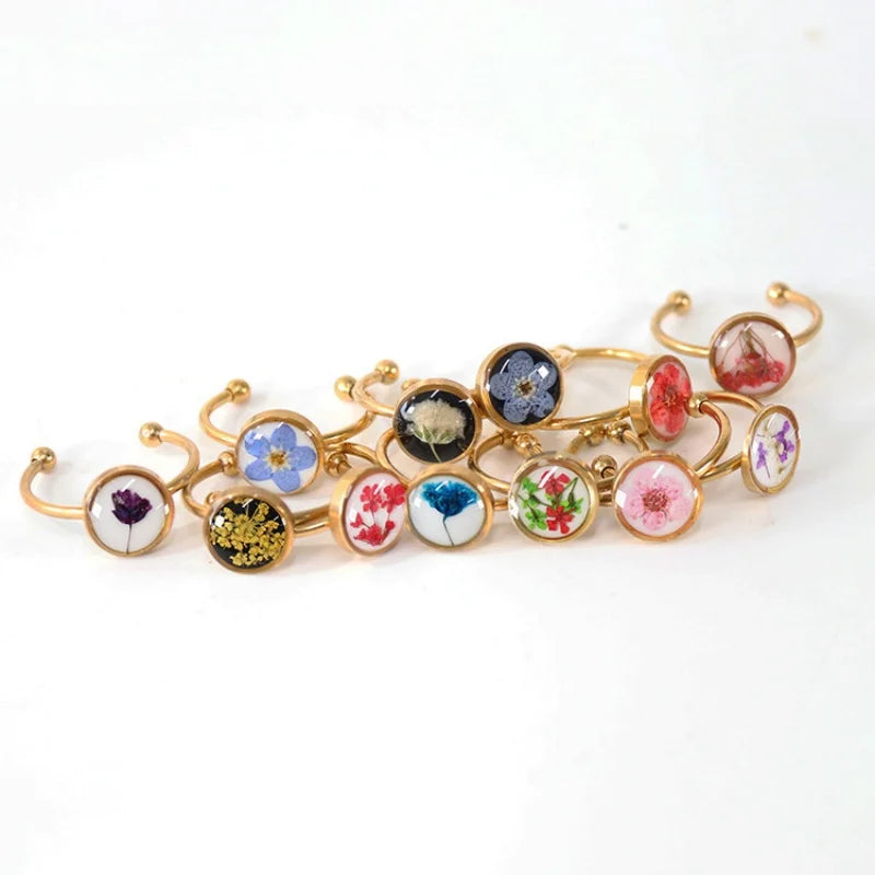 Gold Rings with circular charms featuring floral designs on a white background