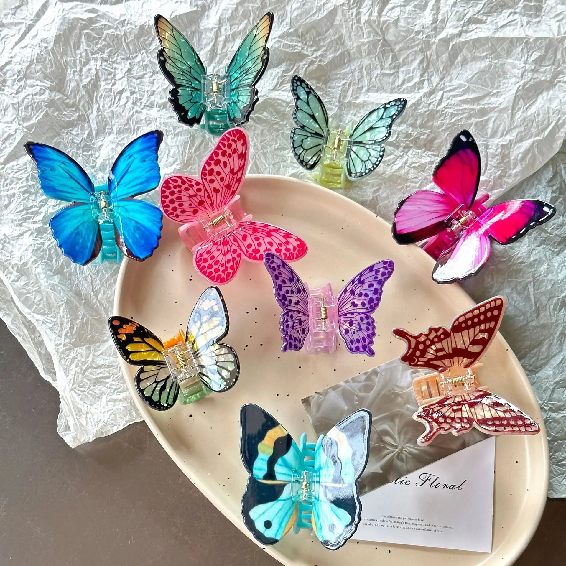 Colorful butterfly-shaped hair clips on a decorative plate with a textured white background.