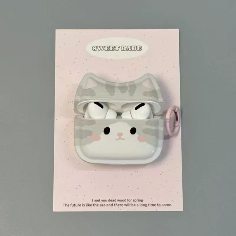 A cute cartoon AirPods case with a smiling cat face and pink cheeks, mounted on a light pink backing card that reads 'SWEET BATE'.