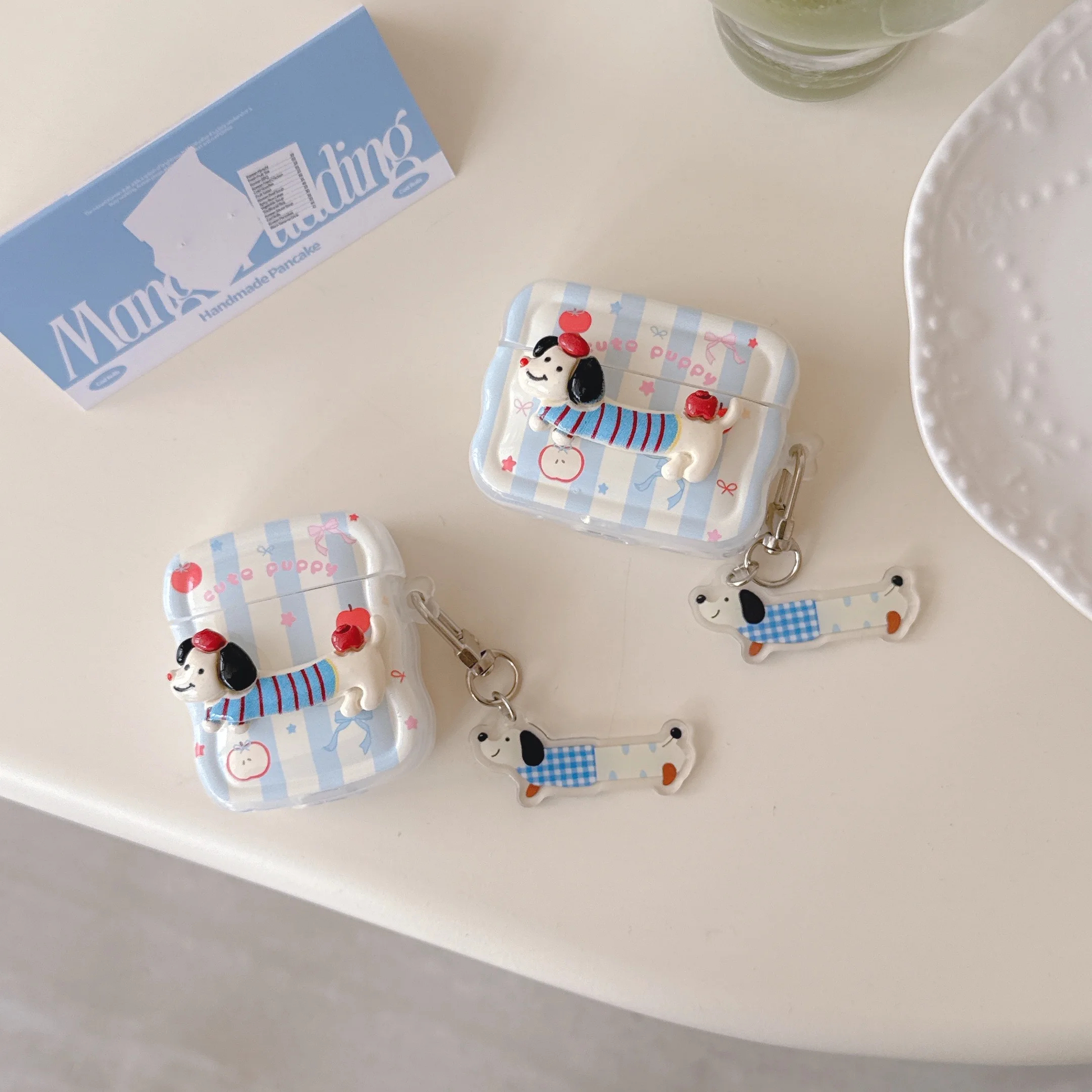 Dog-themed product set including cases and keychains on a white surface.