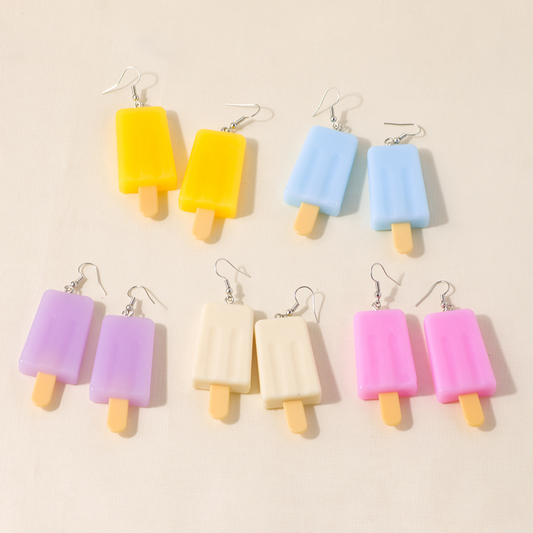 A set of colorful popsicle-shaped earrings in various pastel and bright colors displayed on a surface.